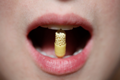 pill between teeht of woman mouth